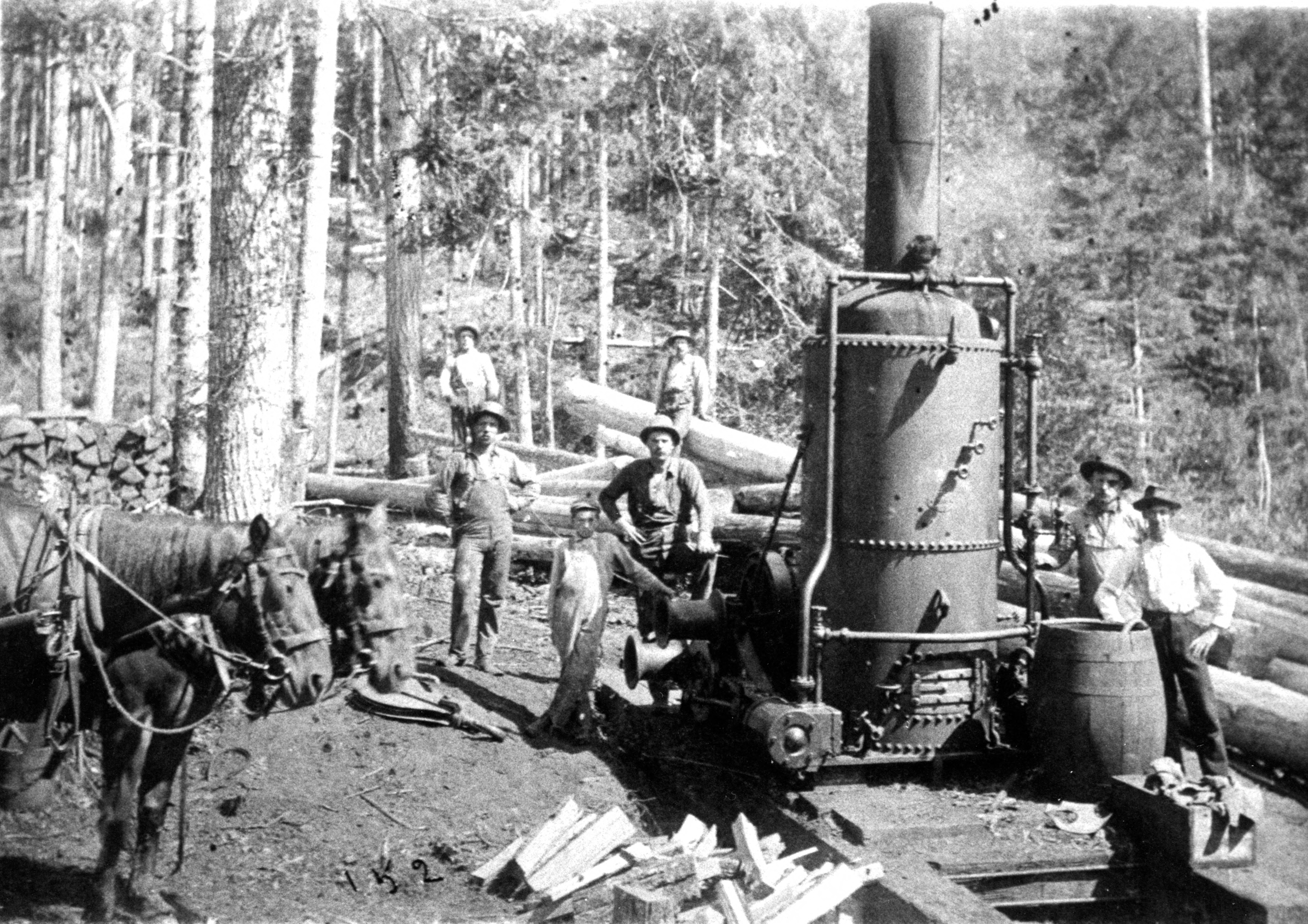Men surrounding a donkey engine