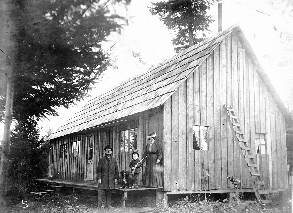 Family in front of a house in a logging camp